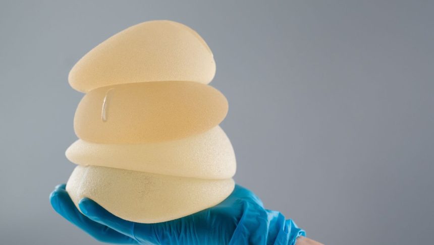 The surgeon held the different sizes of breast implants.